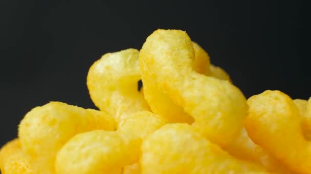 Köstliche knusprige Mais-Chips mit Gewürzen drehen sich im Kreis auf schwarzem Hintergrund - Filmmaterial, Video