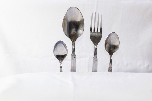 Colheres e garfos, pequenas colheres em um fundo branco
 - Foto, Imagem
