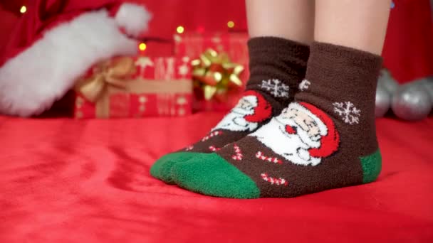 A nők lábai meleg karácsonyi zokniban sétálnak és várják az ünnepi csodát, közelről - Felvétel, videó