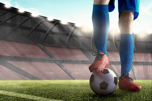 Futbol oyuncusu mavi formalı adam elinde topla futbol sahasında duruyor. - Fotoğraf, Görsel