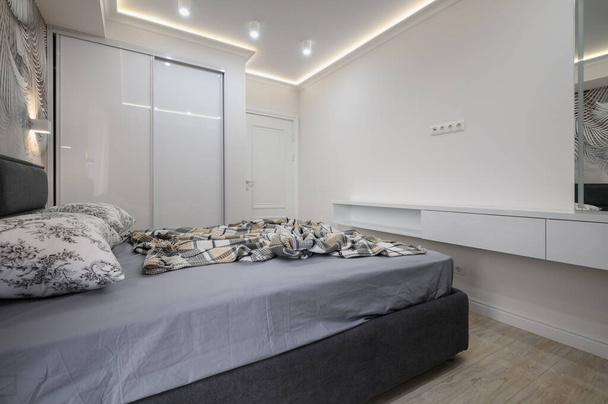 Stilvolles Interieur eines grauen Schlafzimmers mit bequemem Doppelbett - Foto, Bild