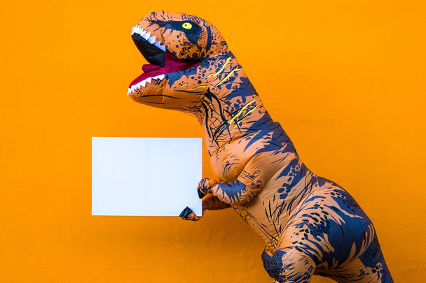 close up and portrait of a t-rex holding a white paper to write your text here - dinosaur holding a copy space  - Photo, Image