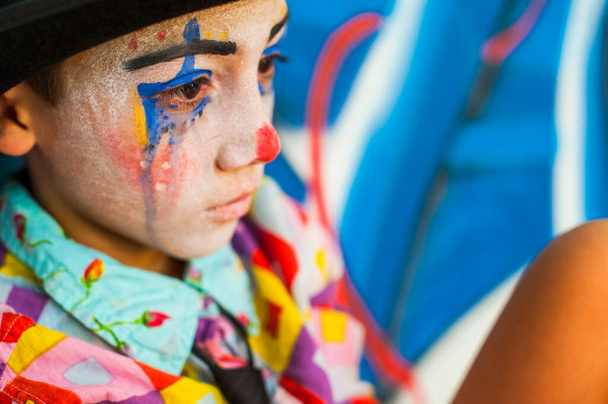 alone boy 8 or 6 years old with clown makeup - sad wearing hat  - Zdjęcie, obraz