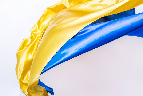 Tkaniny v barvách ukrajinské vlajky vlnící se ve vzduchu na bílém pozadí - Fotografie, Obrázek