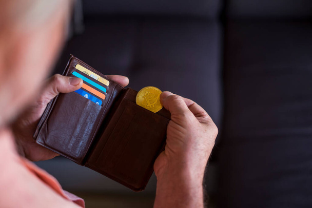 Üstad cüzdanından altın bir bitcoin alıyor - kapalı alanda - gelecek ödeme ve para konsepti  - Fotoğraf, Görsel