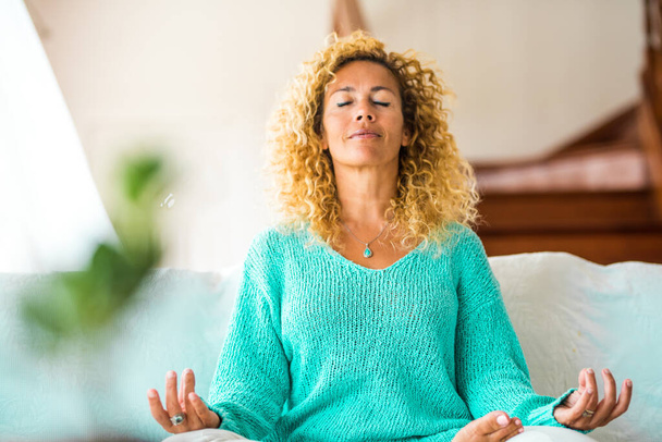 mulher fazendo ioga em casa e relaxar no sofá sozinho dentro de casa - estilo de vida saudável  - Foto, Imagem