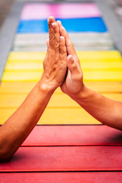 ζευγάρι των ανθρώπων που παίρνουν τα χέρια τους μαζί για να βοηθήσει και να παραμείνουν ενωμένοι με τα χρώματα στο παρασκήνιο - κάνει πέντε  - Φωτογραφία, εικόνα