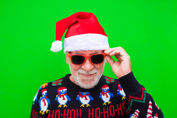 Porträt eines alten, reifen Mannes, der in Weihnachtskleidung in die Kamera lächelt und Weihnachten feiert   - Foto, Bild