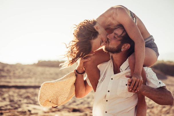 Paar Erwachsene, die Spaß haben und sich küssen - schöner Mann im Stehen und schöne Frau auf dem Kerl, der ihn küsst - romantische und Liebesbeziehung  - Foto, Bild