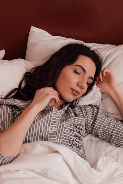 Όνειρο. Όμορφη νεαρή γυναίκα κοιμάται στο κρεβάτι με πιτζάμες. Υψηλής ποιότητας φωτογραφία - Φωτογραφία, εικόνα