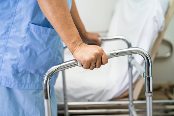 Aasialainen nainen potilas yllään selkäkipu tukivyö ortopedinen lannerangan kanssa kävelijä. - Valokuva, kuva
