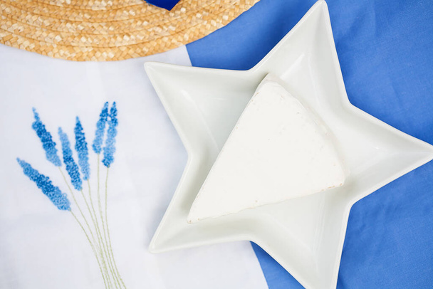 hat, brie cheese in a plate on a blue tablecloth - Photo, Image