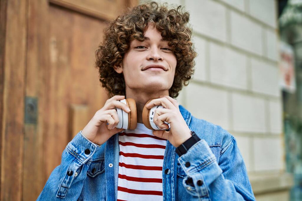 Young hispanic man wearing headphones at the city - Photo, Image