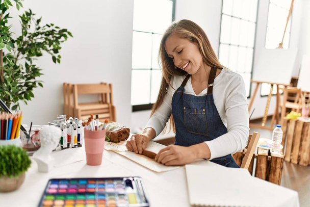 młody biały kobieta uśmiech pewny zrobić ręcznie gliniany garnek w sztuka studio - Zdjęcie, obraz