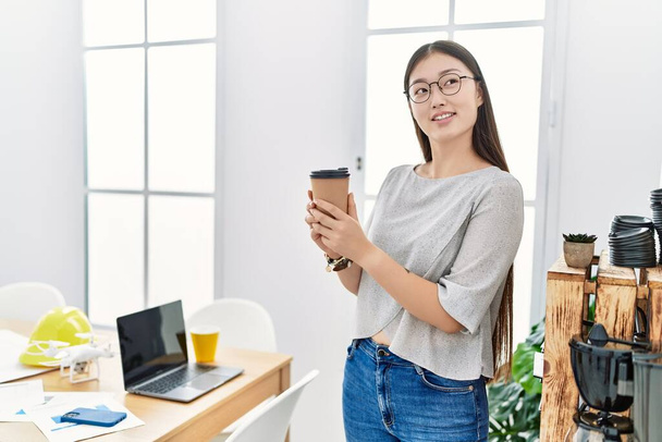 Young asian woman drinking take away coffee at the office - Photo, image