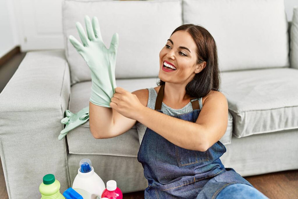 Young beautiful hispanic woman smiling confident wearing gloves at home - Photo, Image