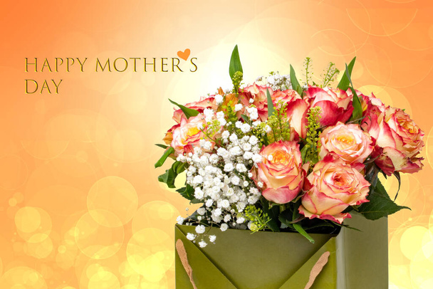 Mothers day greeting card. Decorative composition of a bunch of red yellow roses over abstract bright orange background with Happy mother's Day text. - Foto, Imagem