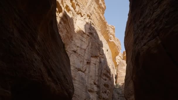 Una passeggiata nel Siq, lo stretto canyon di pietra che funge da passaggio d'ingresso alla città nascosta di Petra, Giordania - Filmati, video