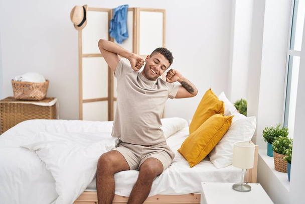 Homme afro-américain se réveillant assis sur le lit dans la chambre - Photo, image