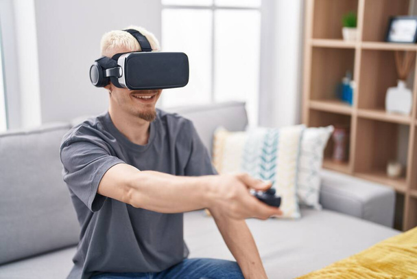 Jovem caucasiano usando óculos de realidade virtual em casa - Foto, Imagem
