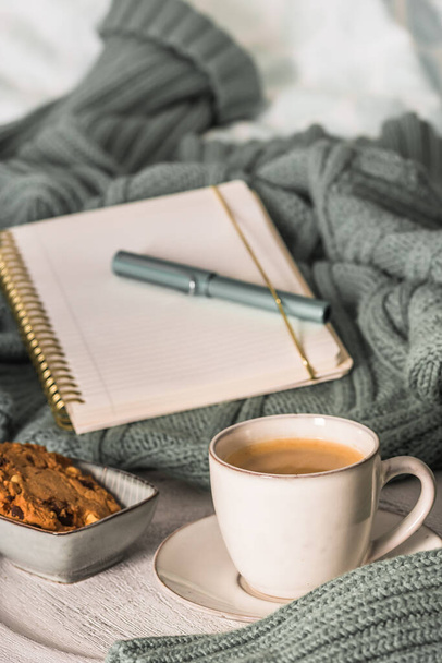 Una taza de café y galletas en una cama acogedora. Jersey de lana caliente para un acogedor fin de semana de otoño, desayuno en la cama, coffee break. Concepto Hygge - Foto, imagen