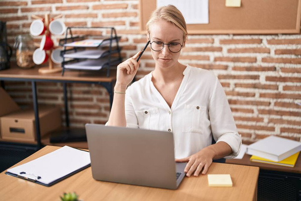 Молодая блондинка бизнес-работница с ноутбука, работающего в офисе - Фото, изображение