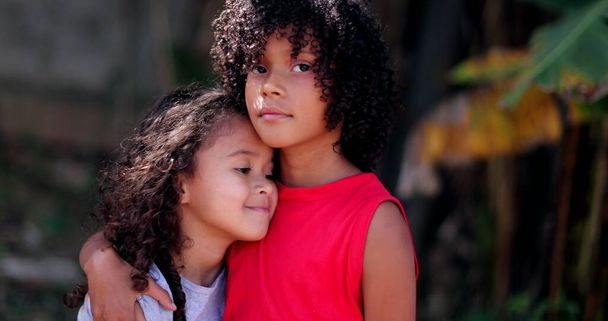 Lapset halailevat toisiaan. Kaksi pientä latino tytöt syleillä - Valokuva, kuva