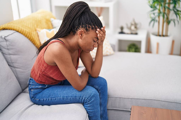 Afrikalı Amerikalı kadın evdeki kanepede otururken strese girdi. - Fotoğraf, Görsel