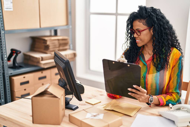 Африканська американська бізнес-працівниця пише на документах, що працюють в офісі - Фото, зображення