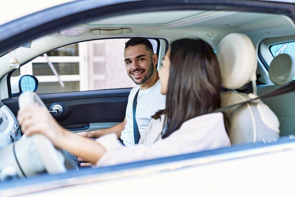 Mladý hispánský pár usměvavý šťastný řízení auta ve městě. - Fotografie, Obrázek