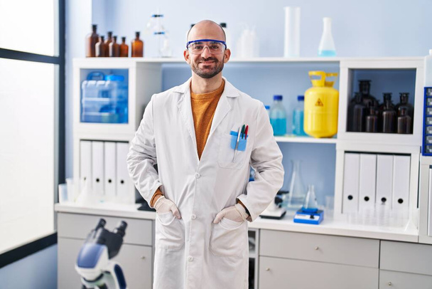 Молодой человек ученый, стоящий в лаборатории - Фото, изображение
