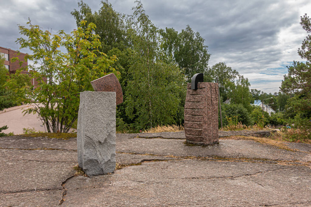 Finsko, Kotka - 18. července 2022: Sopokanlahti park a jezero. Hnědé a šedé moderní sochy skalních menhir jako umění na náhorní plošině pod šedým mrakem. Zelený pás jako pozadí. - Fotografie, Obrázek