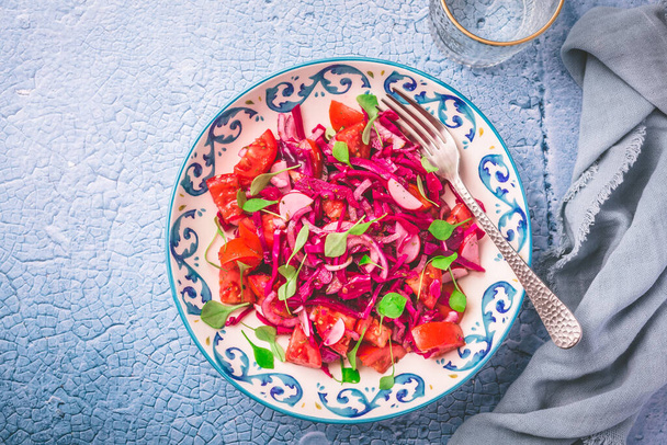 Wintersalat - eingelegter Rotkohlsalat mit Rettich, Tomaten, Zwiebeln und Winterportulak. Vegetarische gesunde Ernährung. - Foto, Bild
