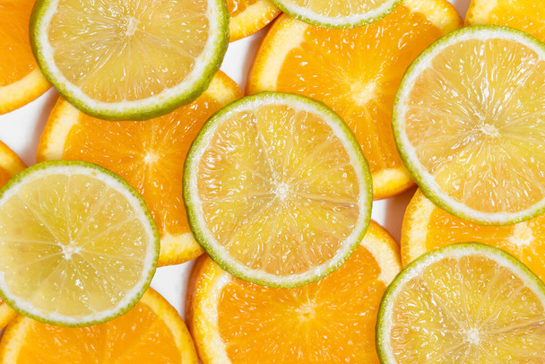 round slices of juicy orange and lime lie on white background. place for your design - Photo, Image