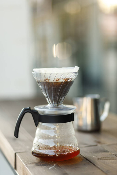 Brewing coffee in a funnel. Pour over Coffee In Funnel. Alternative Method. Beautiful table with dark background. The process of brewing the coffee specialty. Coffee is pouring - Photo, image