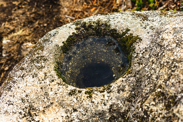 hole in a stone made by erosion or perhaps by prehistoric settlers - Photo, Image