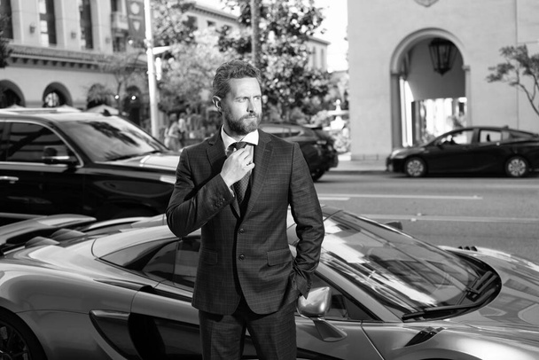 businessman near auto outdoor. handsome man in expensive suit. confident business man rent car. boss stand by luxury automobile. successful dealer. dealership. car insurance. - Photo, Image