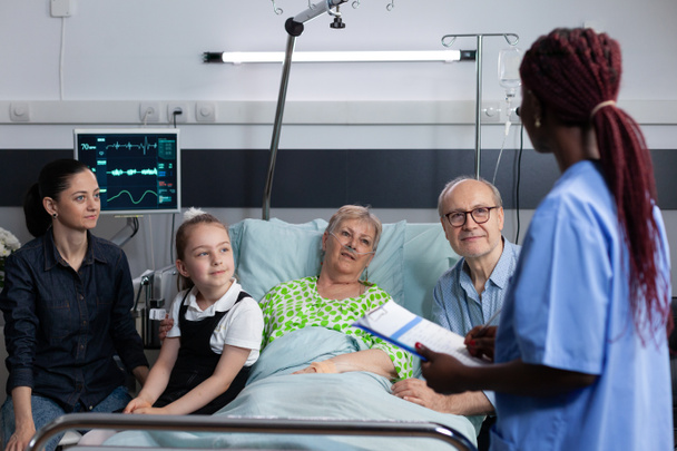 Rodina slyší dobré zprávy o babiččině zdravotním stavu od praktického lékaře v geriatrické nemocnici. Laboratorní lékař hlásí starší ženy výsledky testů na blízké příbuzné. - Fotografie, Obrázek