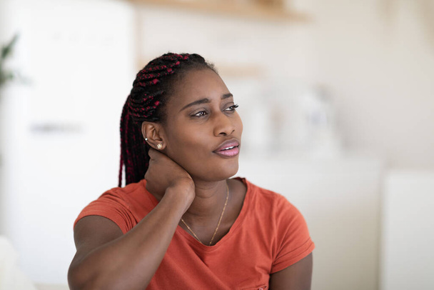 Closeup Portrait Of Dreamy Young African American Woman Relaxing At Home, Pensive Black Female Sitting On Comfortable Couch In Domestic Interior And Looking Away, Resting In Living Room, Copy Space - Photo, Image