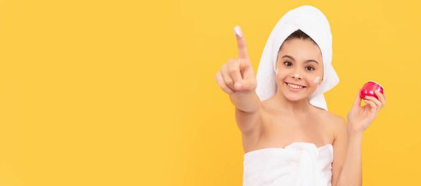 счастливая девушка-подросток в полотенце для душа нанести крем для лица. избирательный фокус. Косметика и уход за кожей для подростка, дизайн плакатов. Баннер с изображением девушки-красавицы - Фото, изображение
