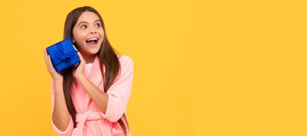 sweet dreams. comfortable pajama or home bathrobe. teen girl feeling surprised. Kid girl with gift, horizontal poster. Banner header with copy space - 写真・画像