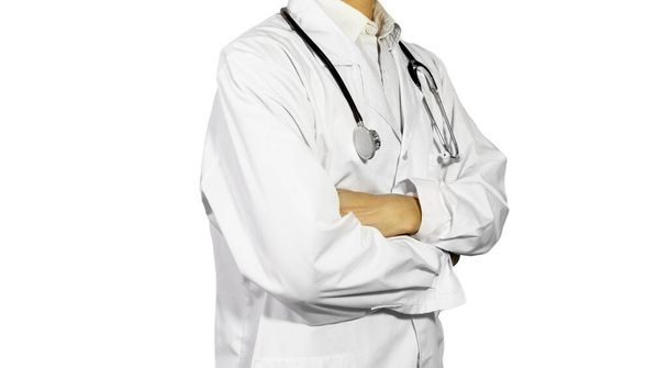 Een halfstaande arts, zonder gezicht, met een stethoscoop tegen een witte achtergrond., staan naast - Foto, afbeelding