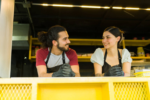 Attractive hispanic chef and workers at the food truck looking happy while waiting for customers - Foto, imagen