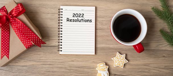 2022 Резолюції з зошитом, чорною чашкою кави, різдвяним печивом і ручкою на дерев'яному столі, верхнім видом і копіюванням простору. Xmas, Happy New Year, Goals, To do list, Strategy and Plan - Фото, зображення