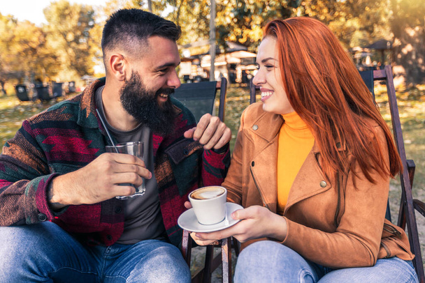Bella coppia amorevole seduta in un caffè godendo in caffè e conversazione
. - Foto, immagini