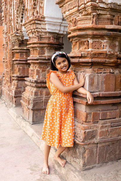 Ładne indiańskie dziecko dziewczyny w pobliżu terakoty rozciągacz Zachodniego Bengalu - Zdjęcie, obraz