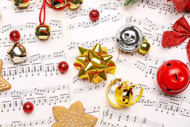 Лук с рождественскими колокольчиками на нотных листках, крупным планом - Фото, изображение