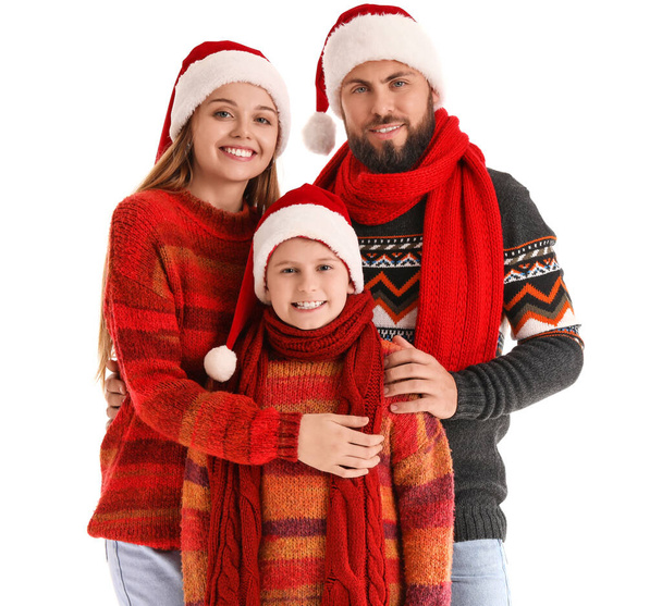 Onnelliset vanhemmat pienen poikansa kanssa Santa hatut ja lämpimät vaatteet valkoisella taustalla - Valokuva, kuva