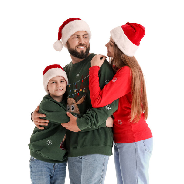 Mutlu ebeveynler ve beyaz arka planda Noel Baba şapkalı küçük oğulları. - Fotoğraf, Görsel