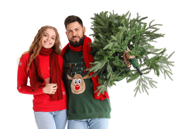 Happy young couple with Christmas tree on white background - Photo, Image